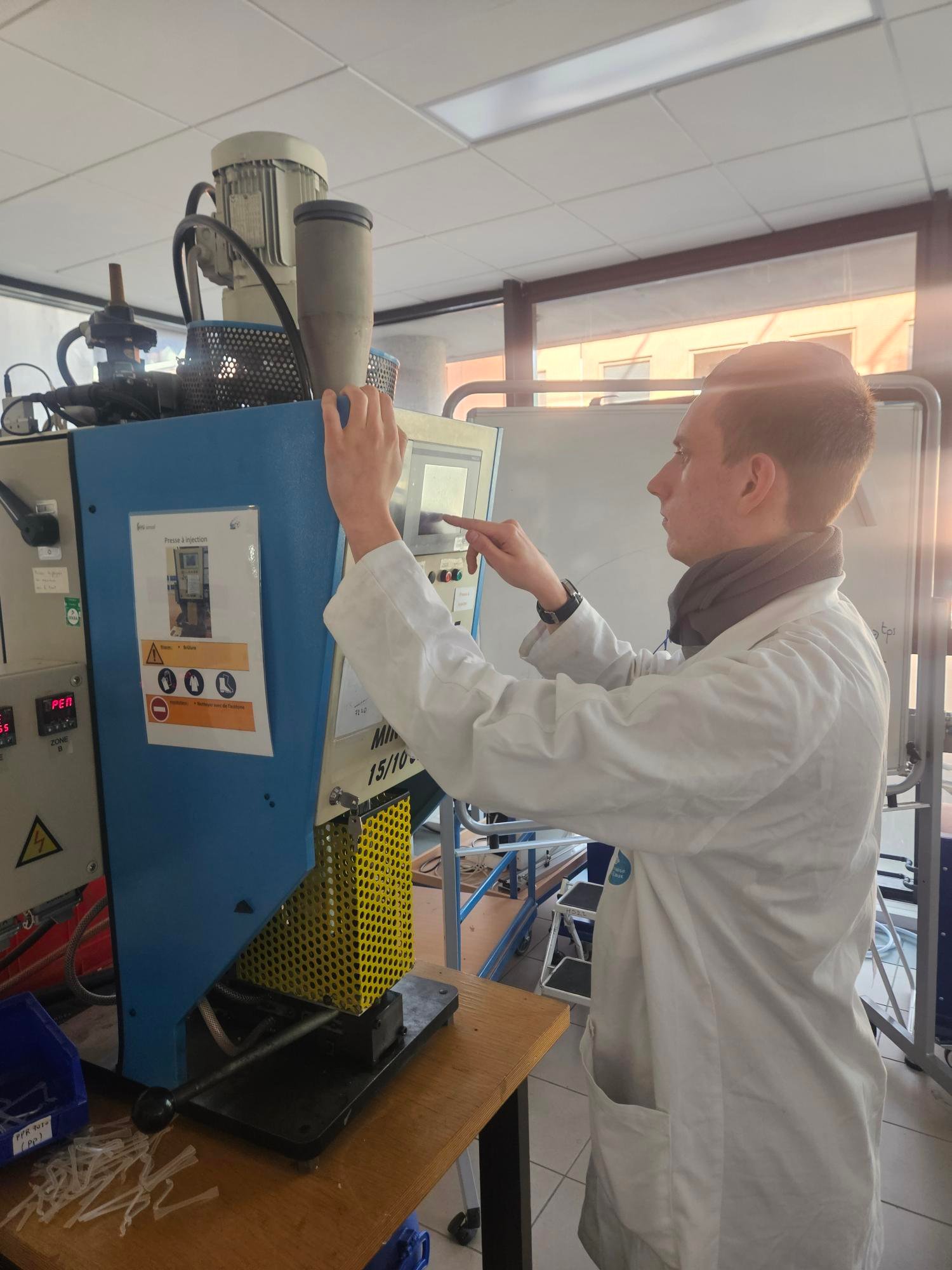 Hugo en train de régler une machine à injection